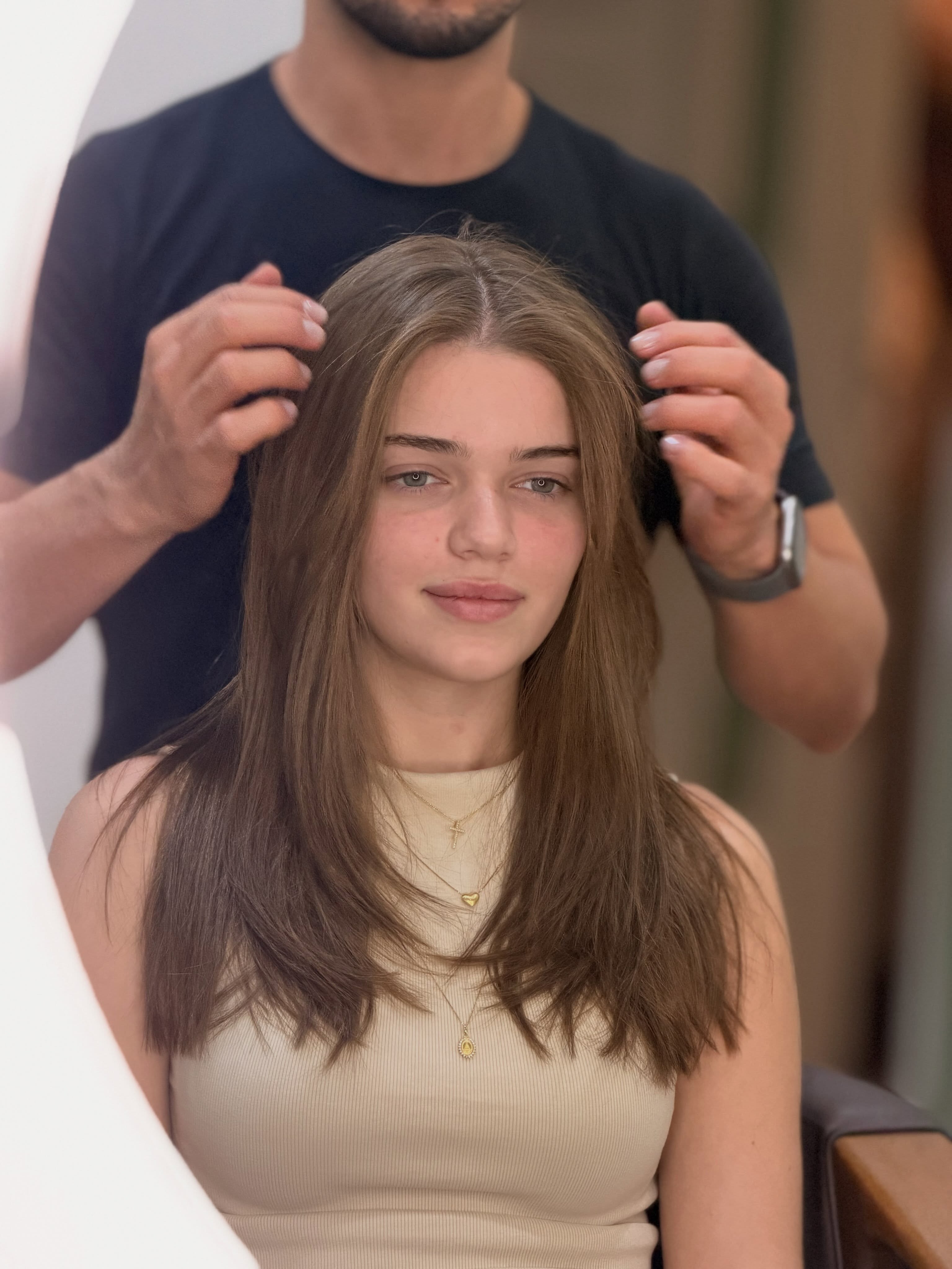 Cliente com cabelo longo castanho durante atendimento no salão