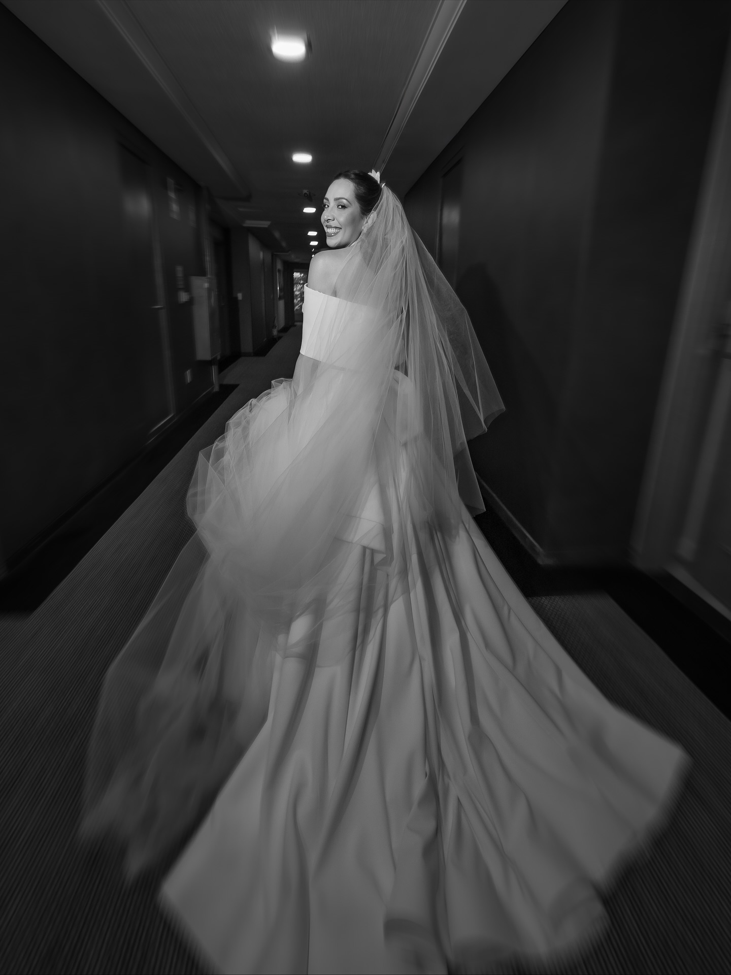 Noiva caminhando em corredor com vestido e véu